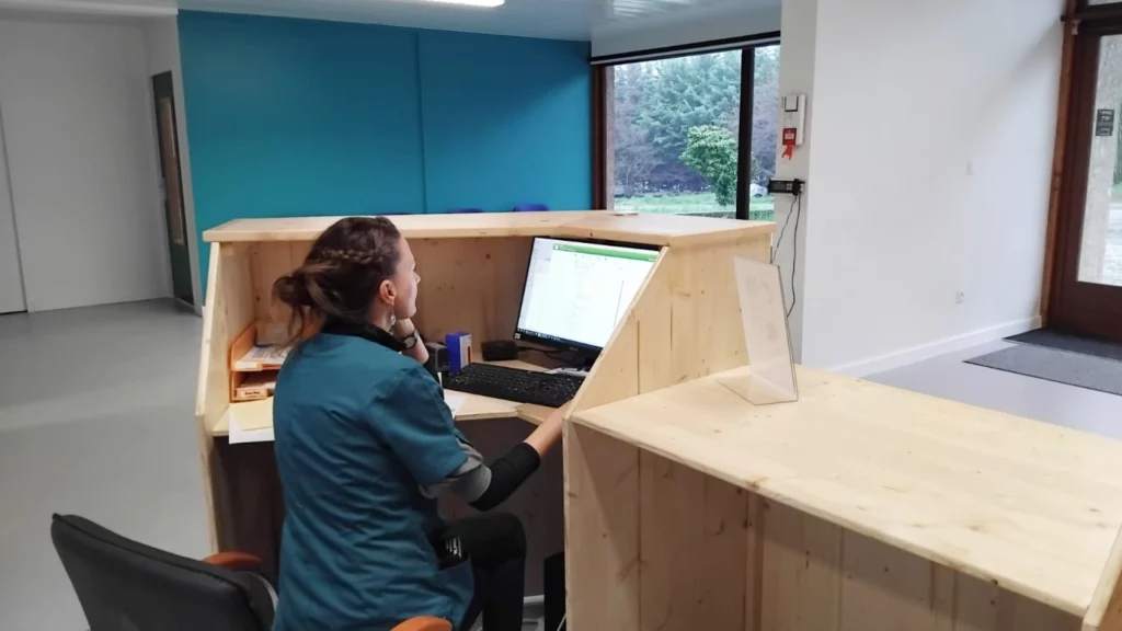 vetipole-clinique-veterinaire-accueil Dr Balligand prenant des RDV à l'accueil de la clinique.